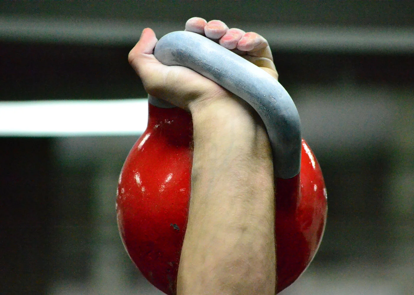 Mão empunhando a alça de um kettlebell de competição NRRU